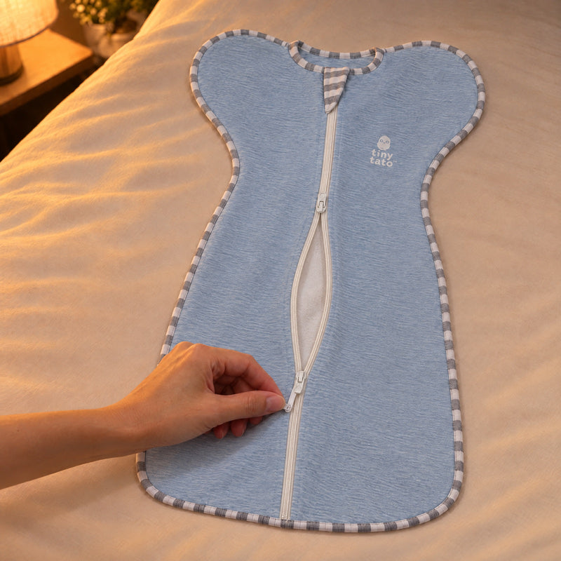 Hand opening the lined two-way zip of a Baby Sky TatoWrap from the lower slider for a nappy change