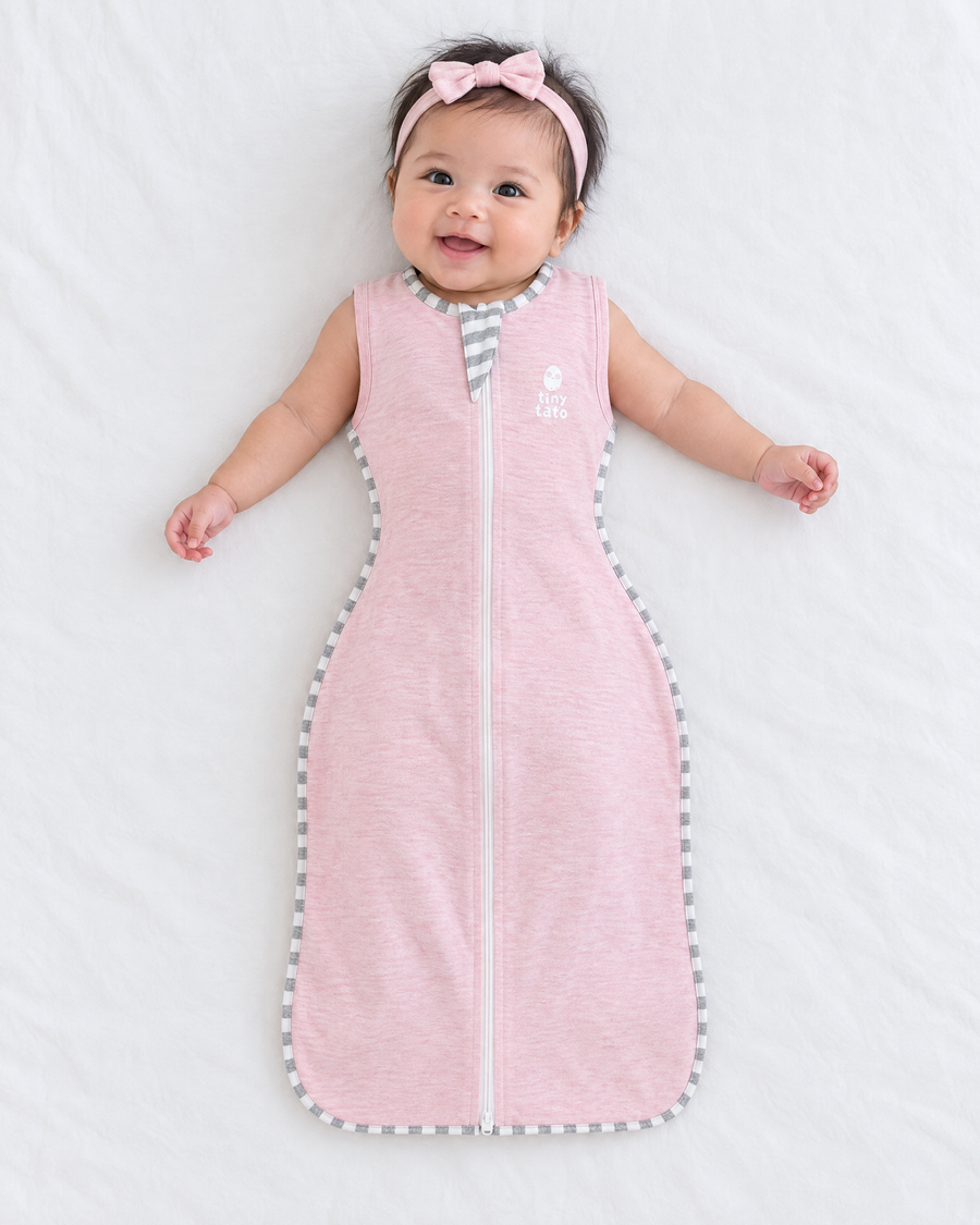 Baby girl in a Baby Blush TatoWrap+ zip swaddle with the sleeves off