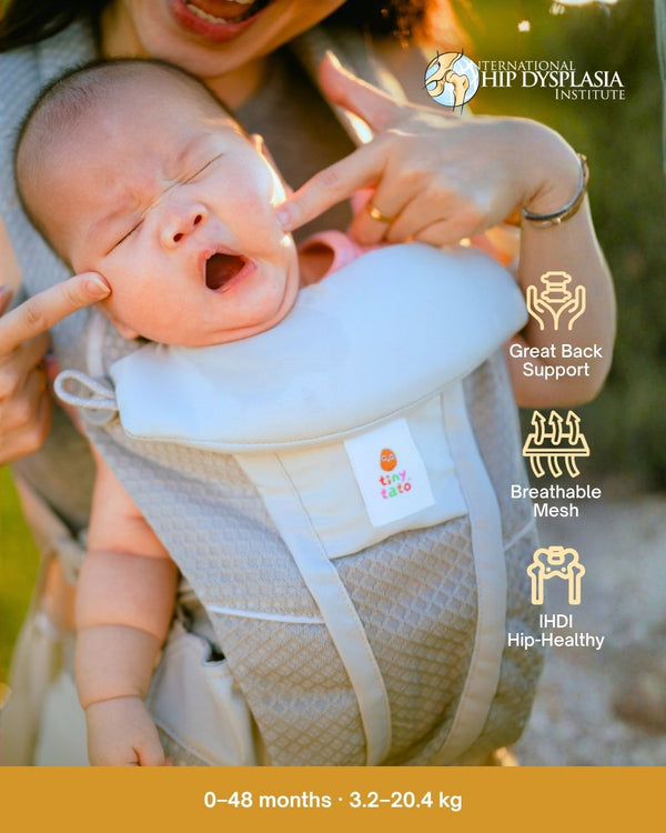 Newborn in a TatoSnug structured baby carrier with breathable mesh and padded head support